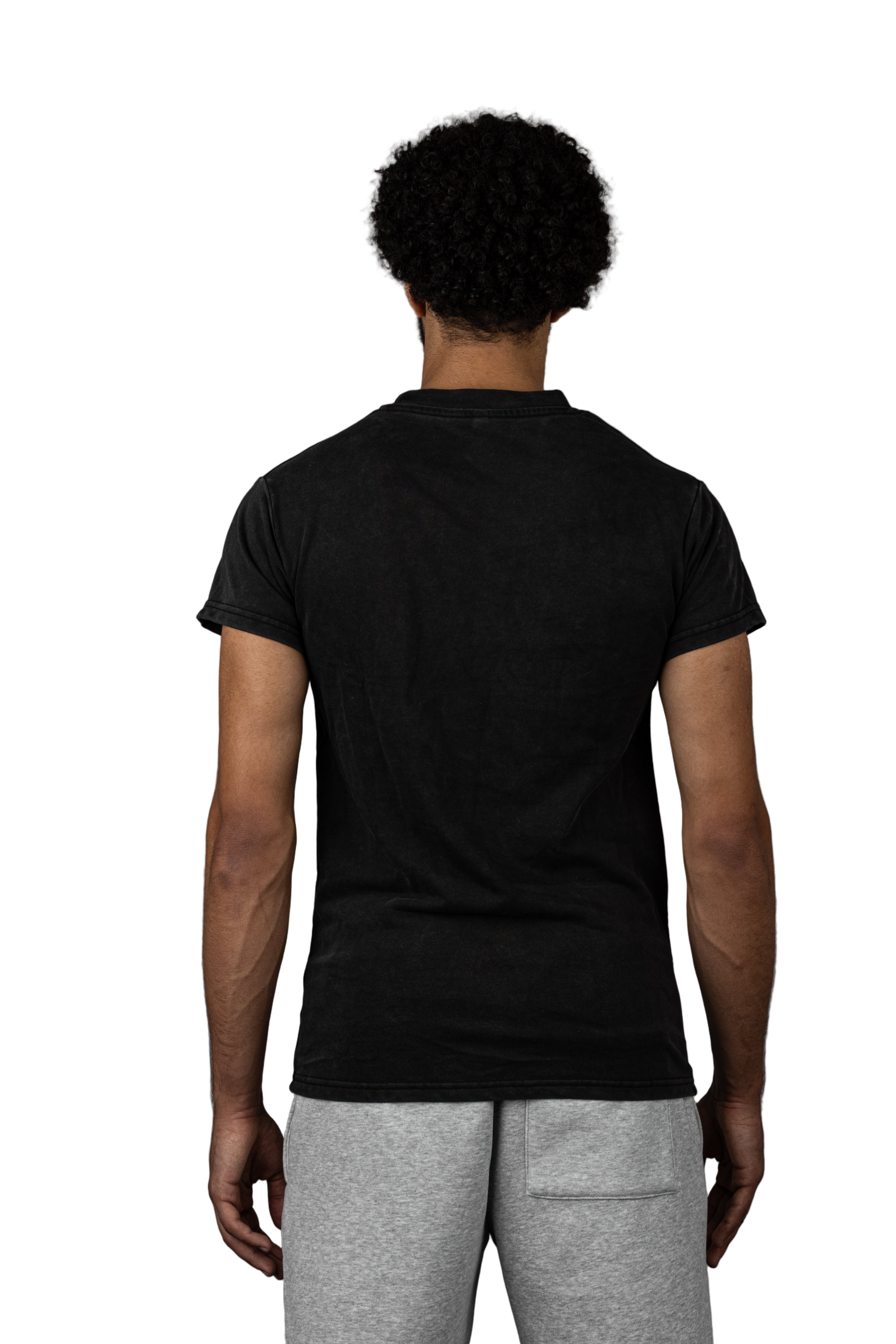 Person wearing salaam apparel black t-shirt and gray pants against a gray background